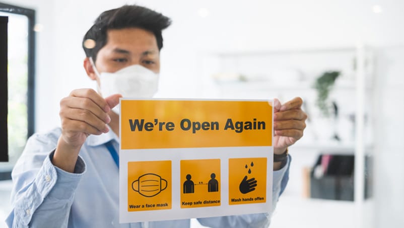 employer putting up COVID sign to welcome back employees to work